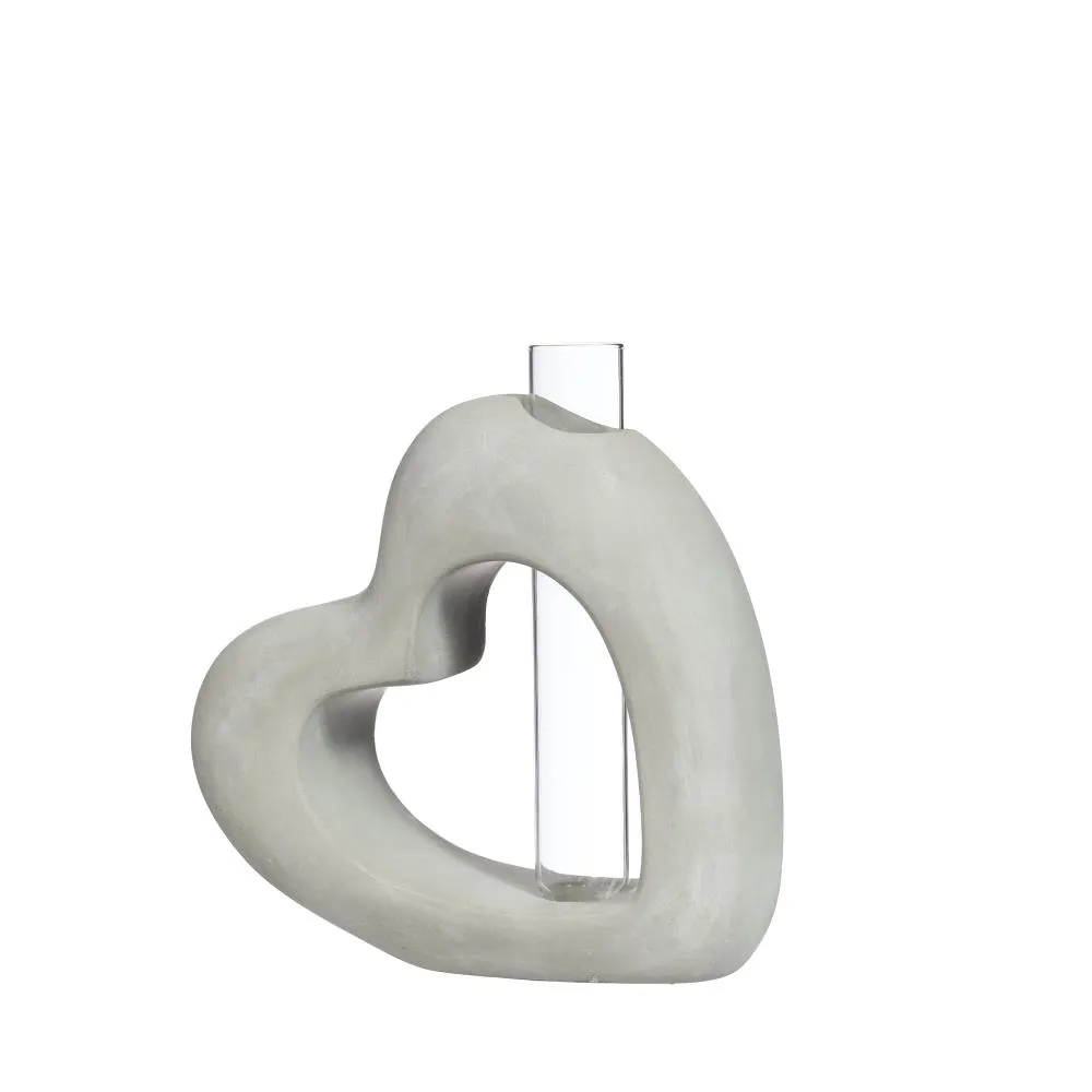 Heart-shaped concrete object with a clear cylindrical center on a white background
